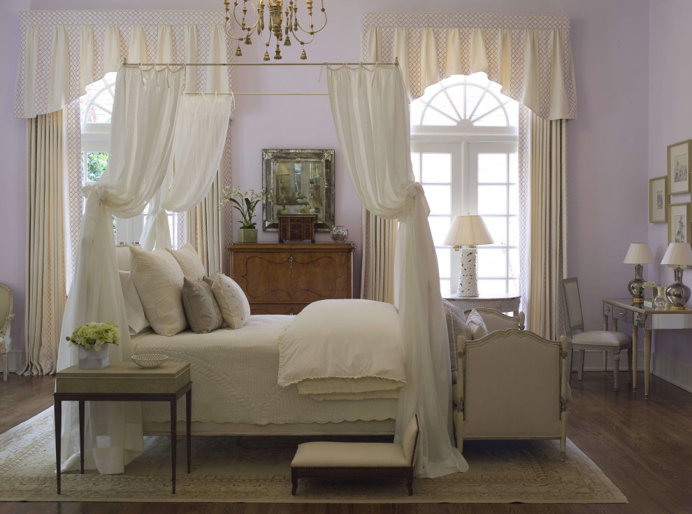 Кровать с балдахином в комнате с высокими окнами