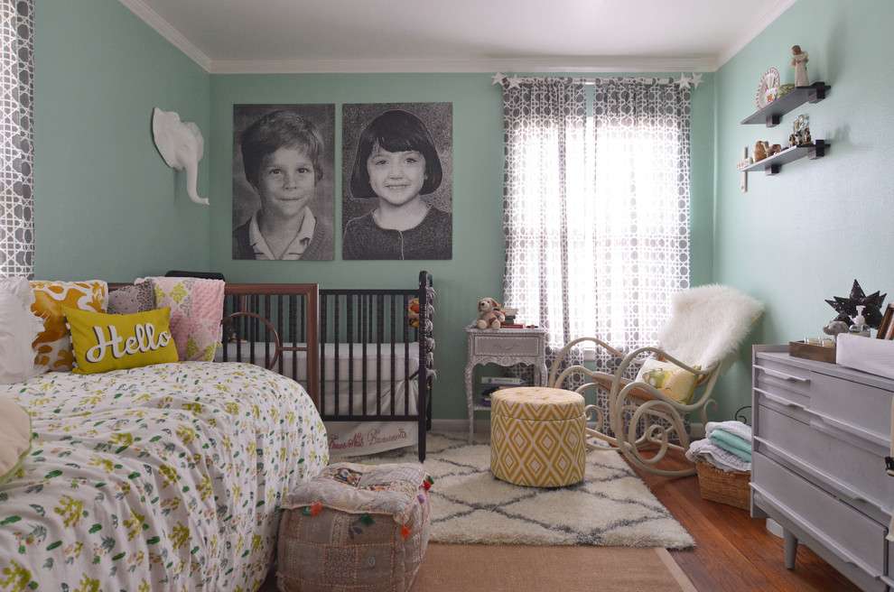 Портреты родителей на стене спальни с детской кроваткой