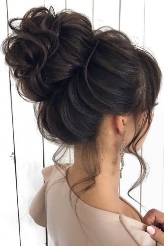 wedding hairstyles for long hair textured high bun on dark hair with loose curls mpobedinskaya